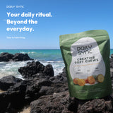 Real Daily Sync Mango & Pineapple pouch photographed by the coast